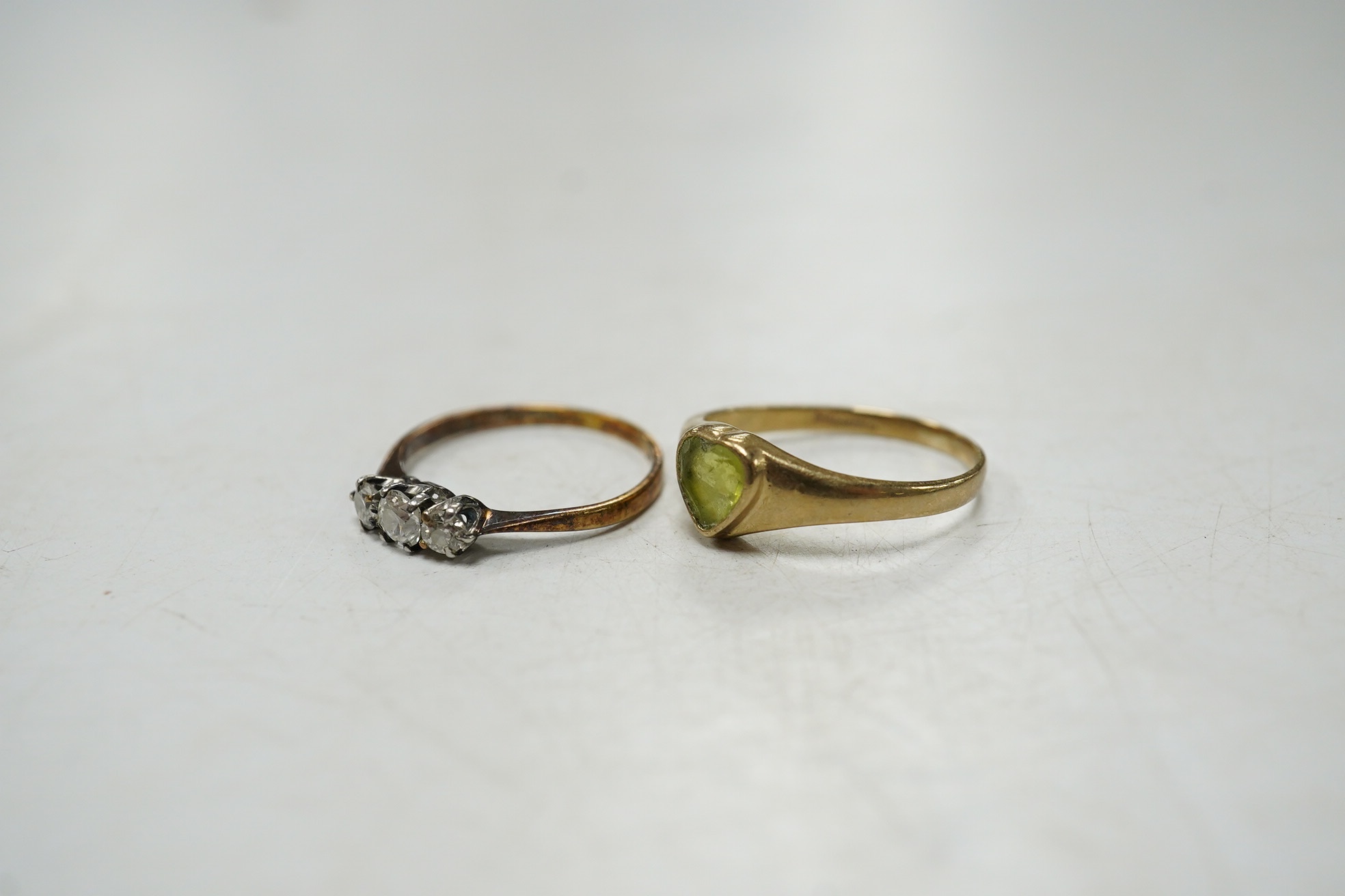 An 18ct and three stone diamond set ring, size G and one other 9ct gold and heart shaped green stone set ring. Condition - poor to fair